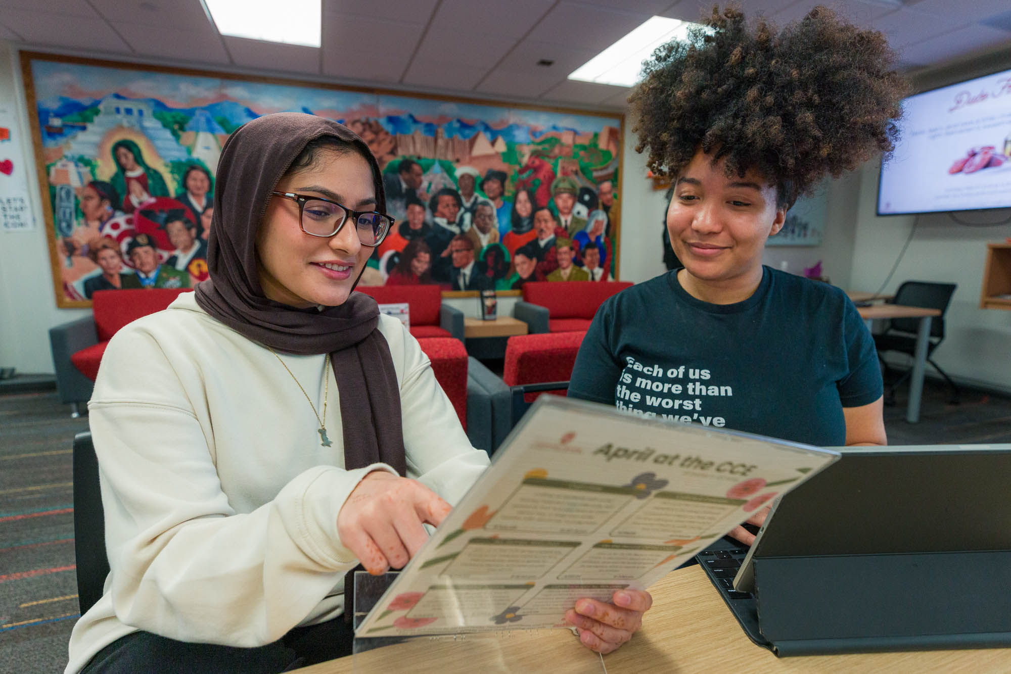 Amara Ahmad talks about upcoming events with another student employee in the Center for Cultural Enrichment (CCE) in Witte Residence Hall.
