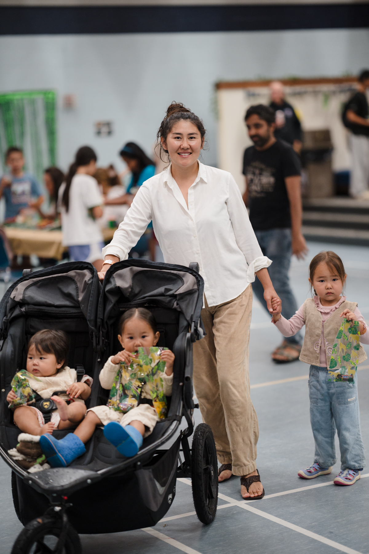 Women with three kids, two sitting in the stroller
