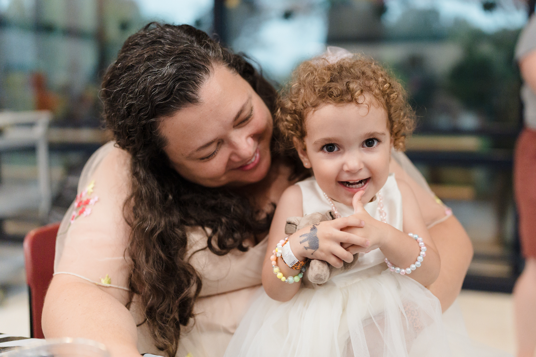 Young girl smiling while parent holds her