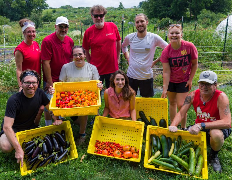 Dining staff pose at the Campus Farm with produce