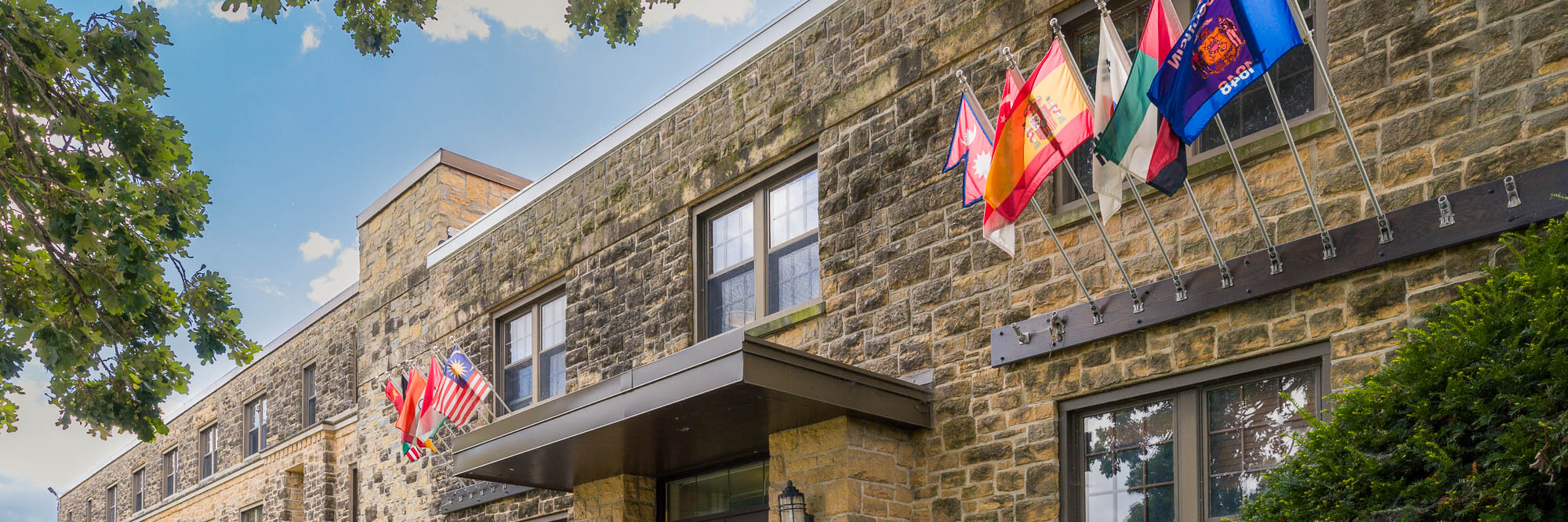 Flags of various countries and the Wisconsin state flag flying on Kronshage Residence Hall