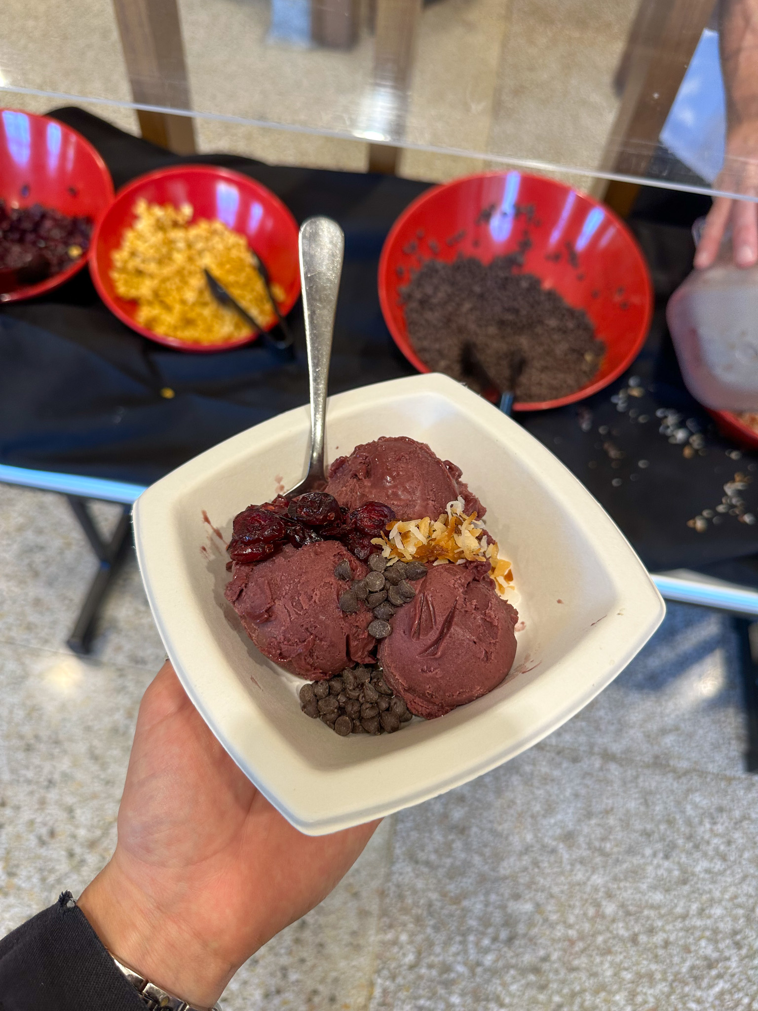Acai bowl with toppings in the background