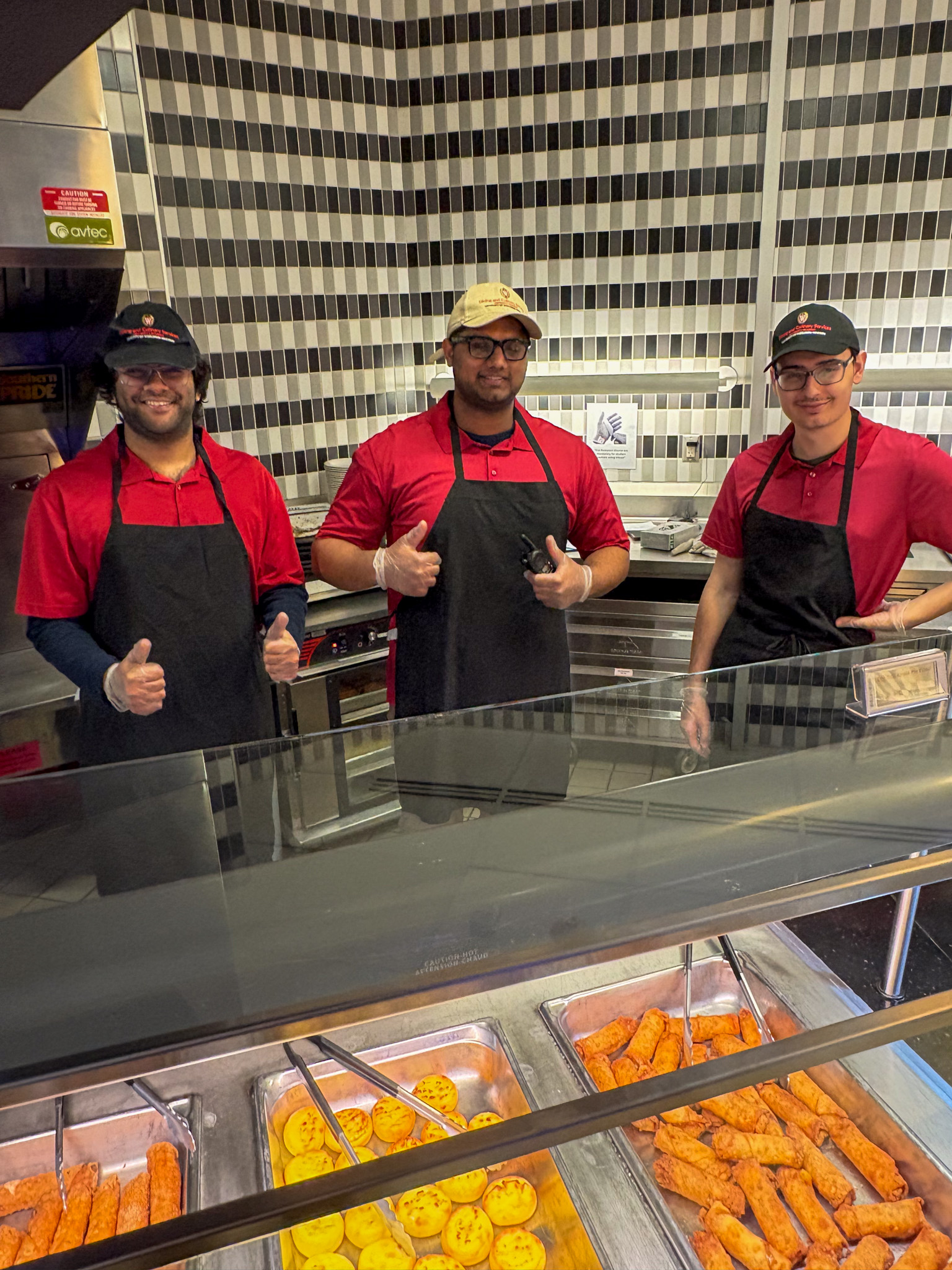 Student employees pose at station during Late Night Breakfast