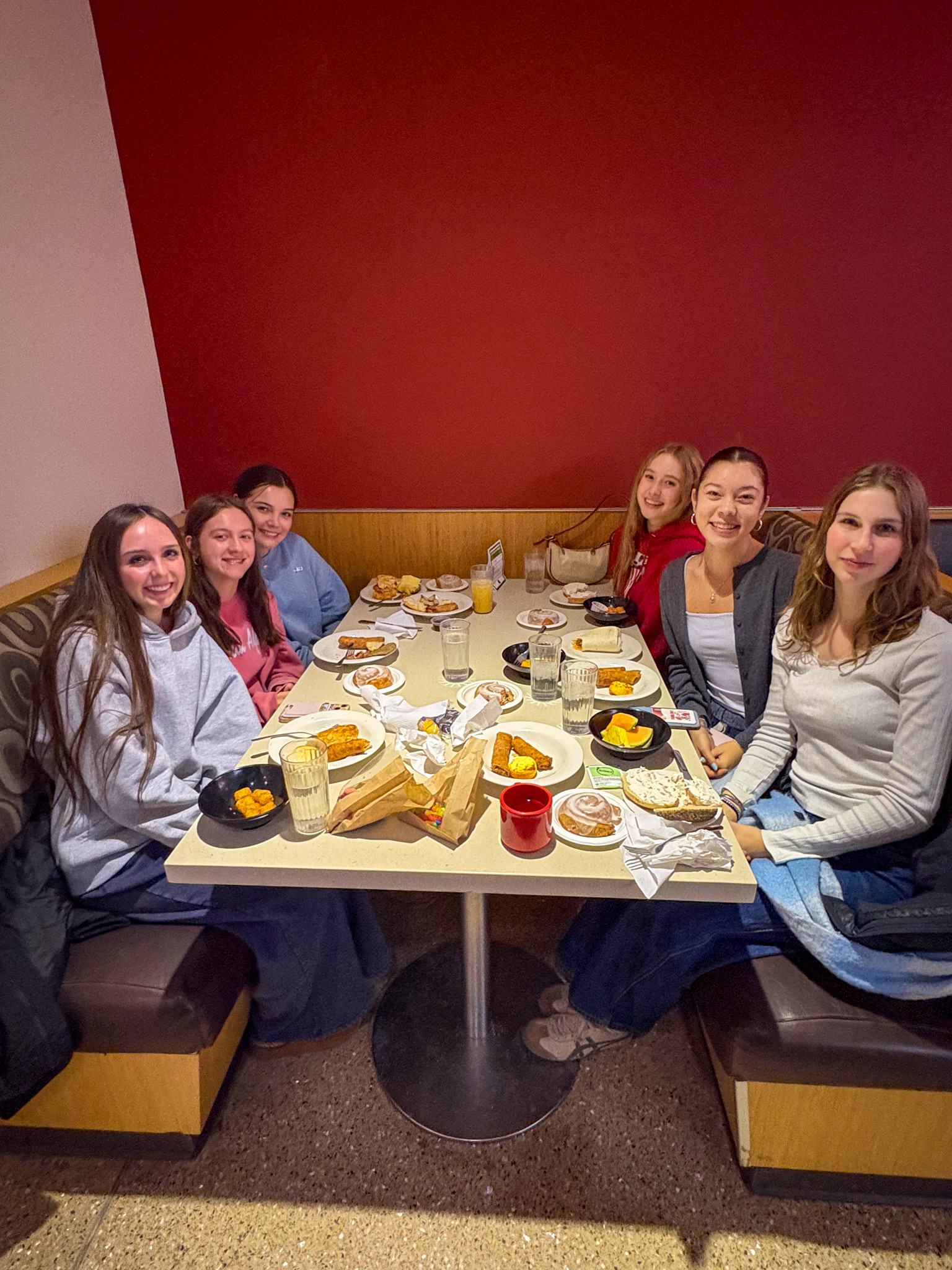 Group of students pose for photo at their table during Late Night Breakfast