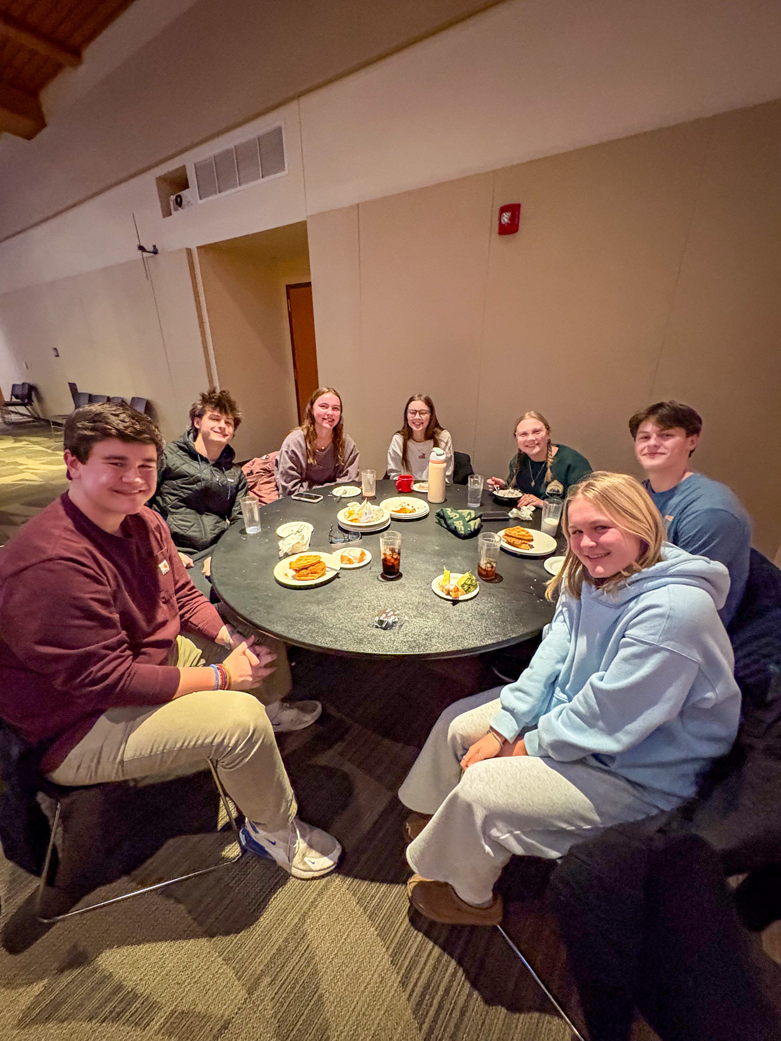 Group of students pose for photo at their table during Late Night Breakfast