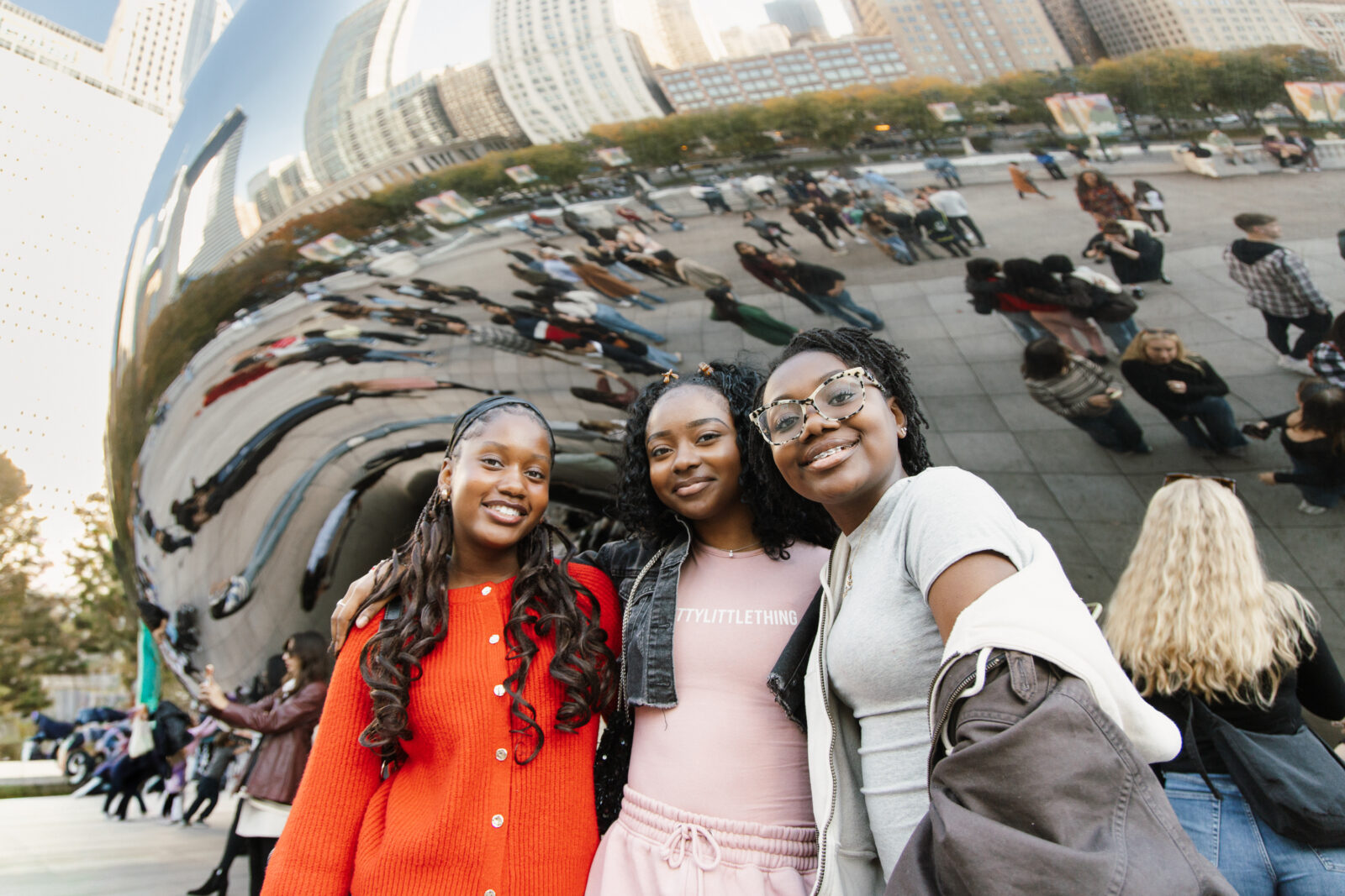 Three people posing in front of The Bean in Chicago, Illinois.