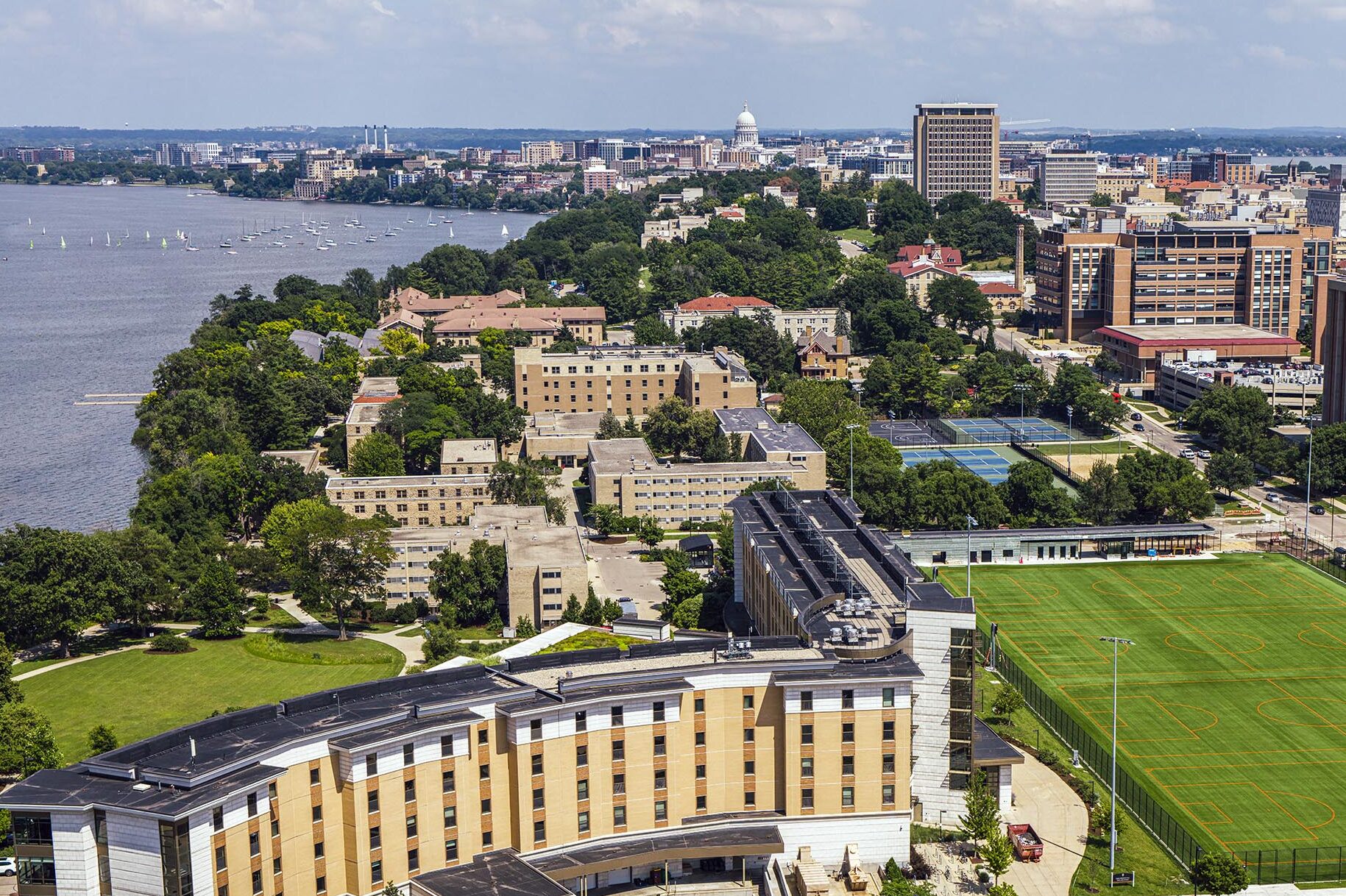 The west side of campus including Dejope Residence Hall, the Near East Fields, and the Lakeshore neighborhood are photographed by a drone with the Capitol and the campus skyline on a partly cloudy summer day at the University of Wisconsin–Madison on July 9, 2025.