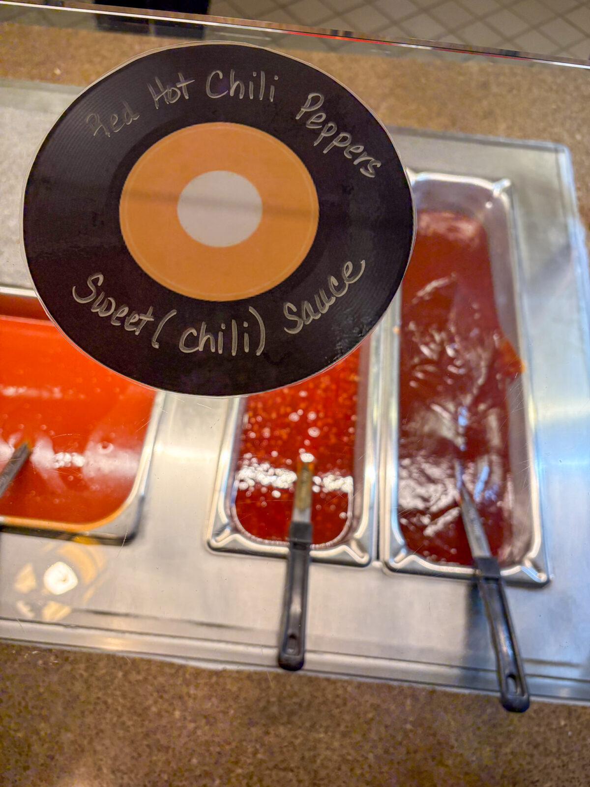 Red Hot Chili Peppers Sweet (Chili) Sauce record sign with chili sauce in the background