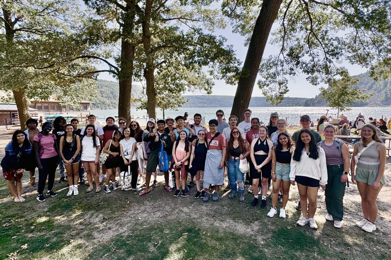 A large group poses with trees and Devil's Lake in the background.