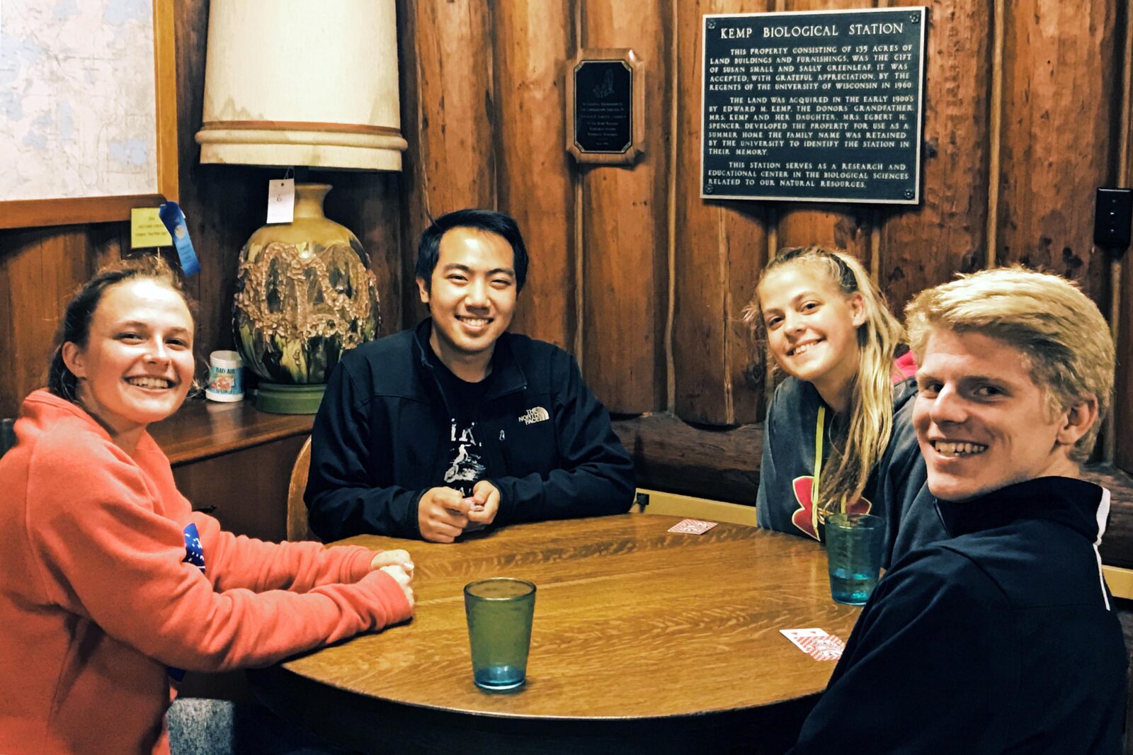 Four people sit at a table playing cards at Kemp Biological Station.