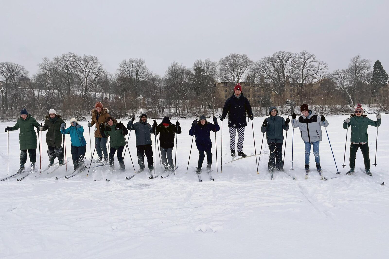 A group of people pose for a photo on skis in a line.