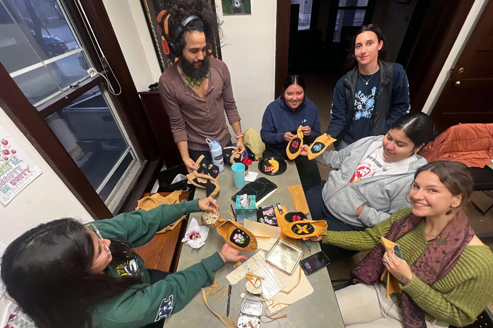 A group of people designing moccasins at a table.