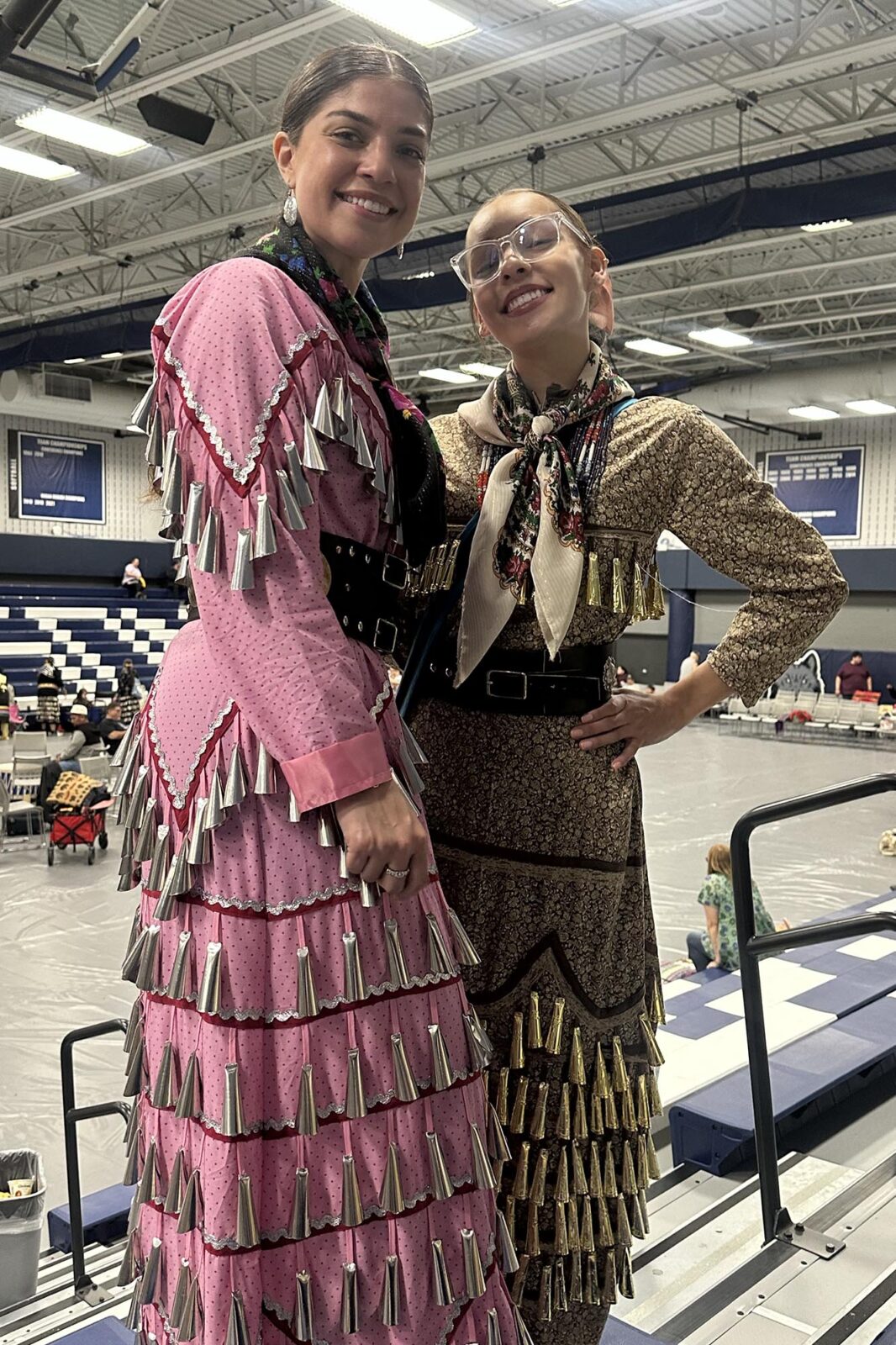 Two people posing in traditional Native American dress.