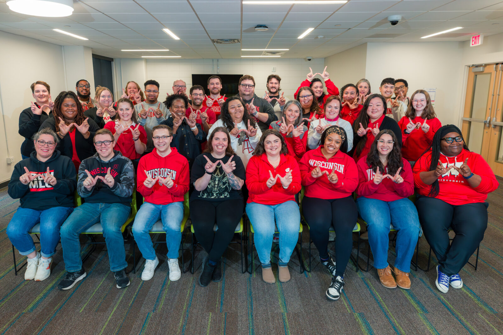 UW Res Life Pro Staff showing the "W" and smiling at the camera