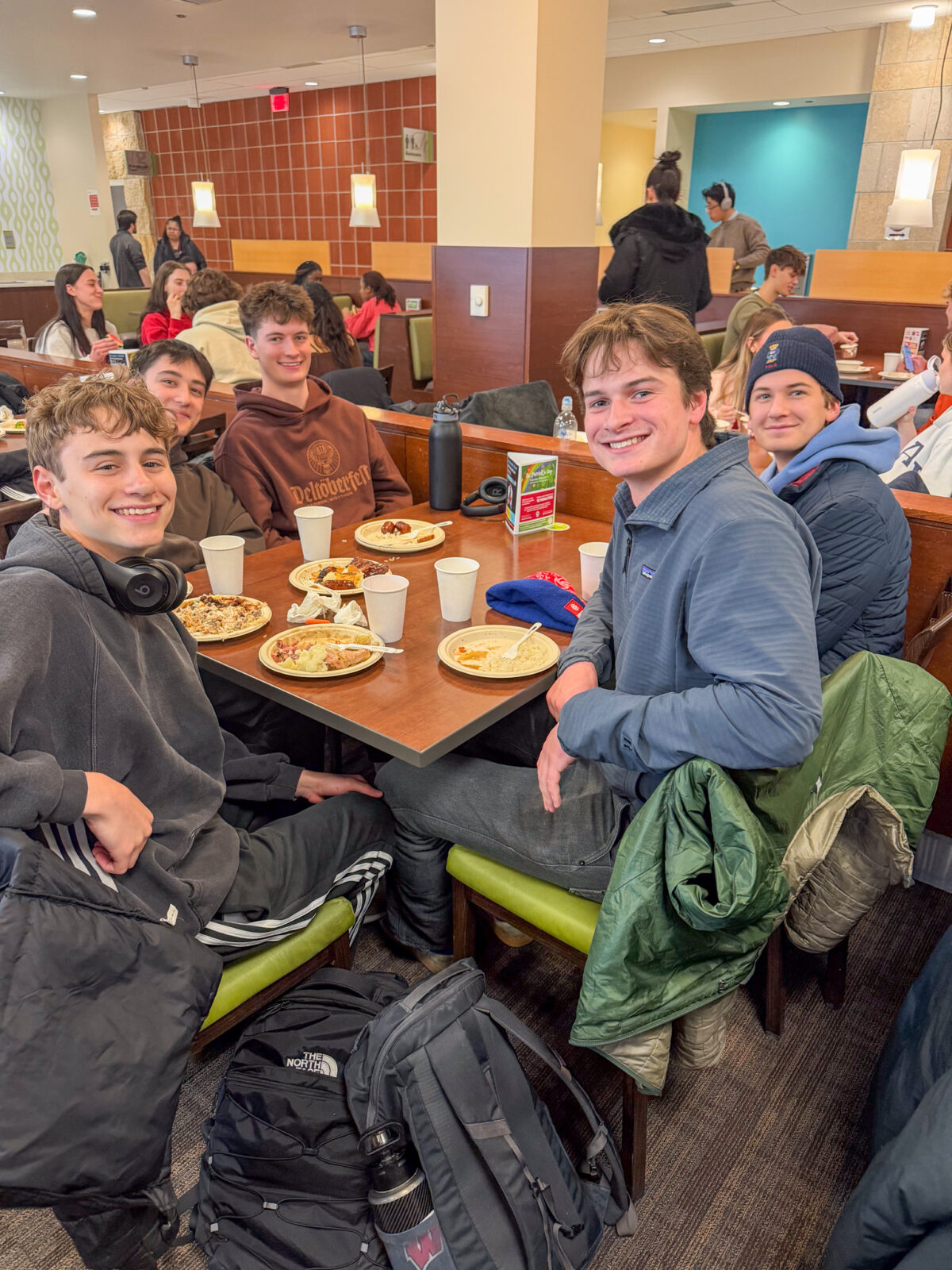 Group of students dining at St. Patrick's day event pose for photo