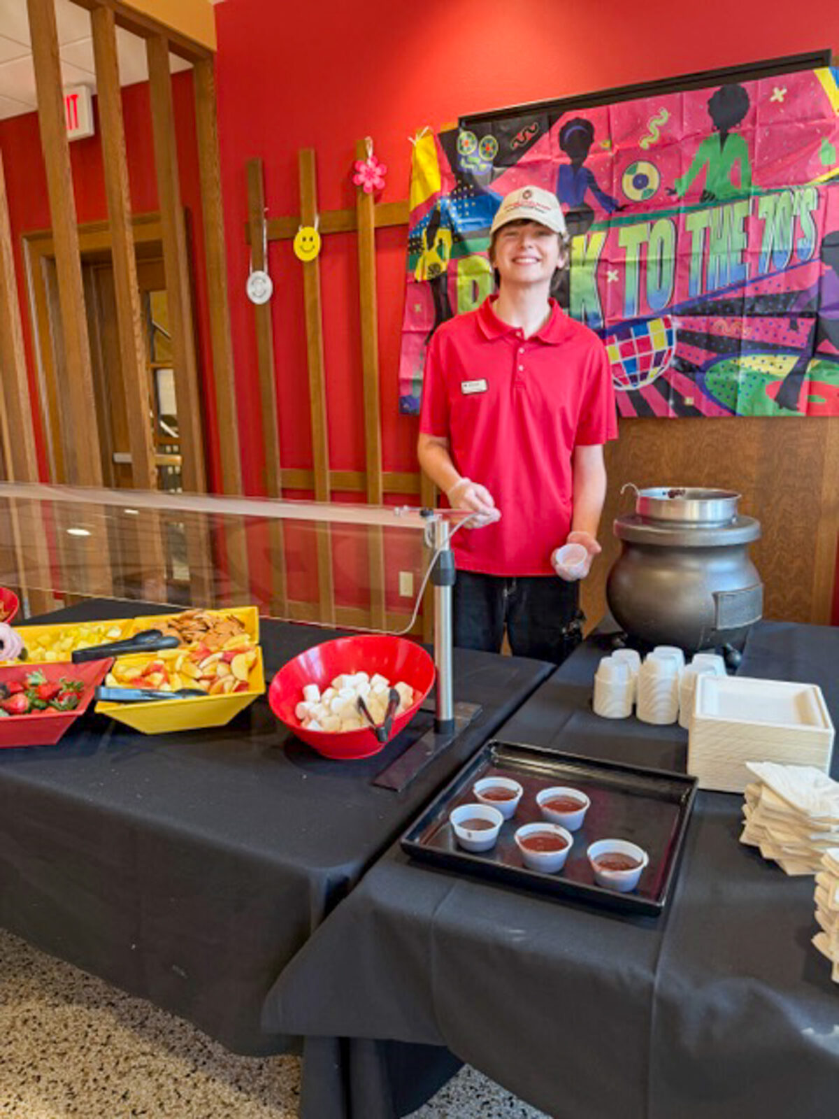 A student staff member poses for photo at Carson's 70's Night event
