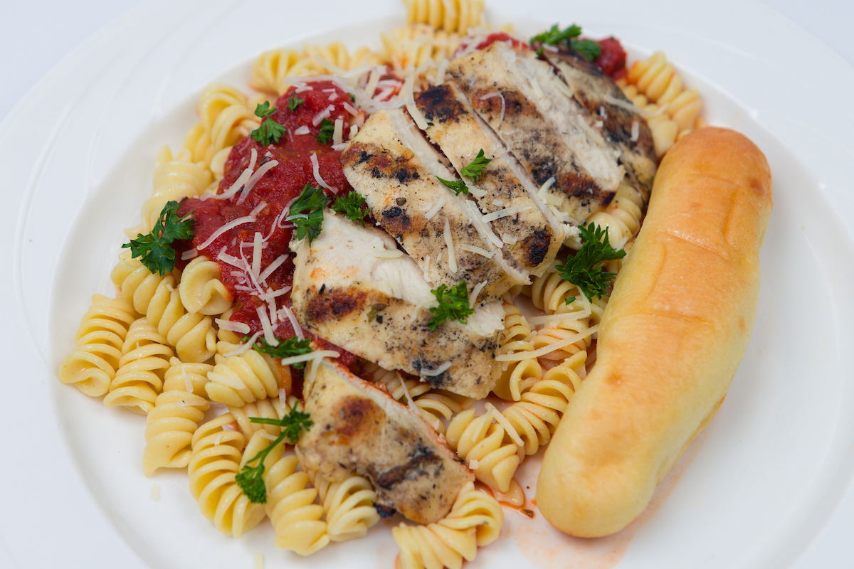 Pizza with chicken and a breadstick