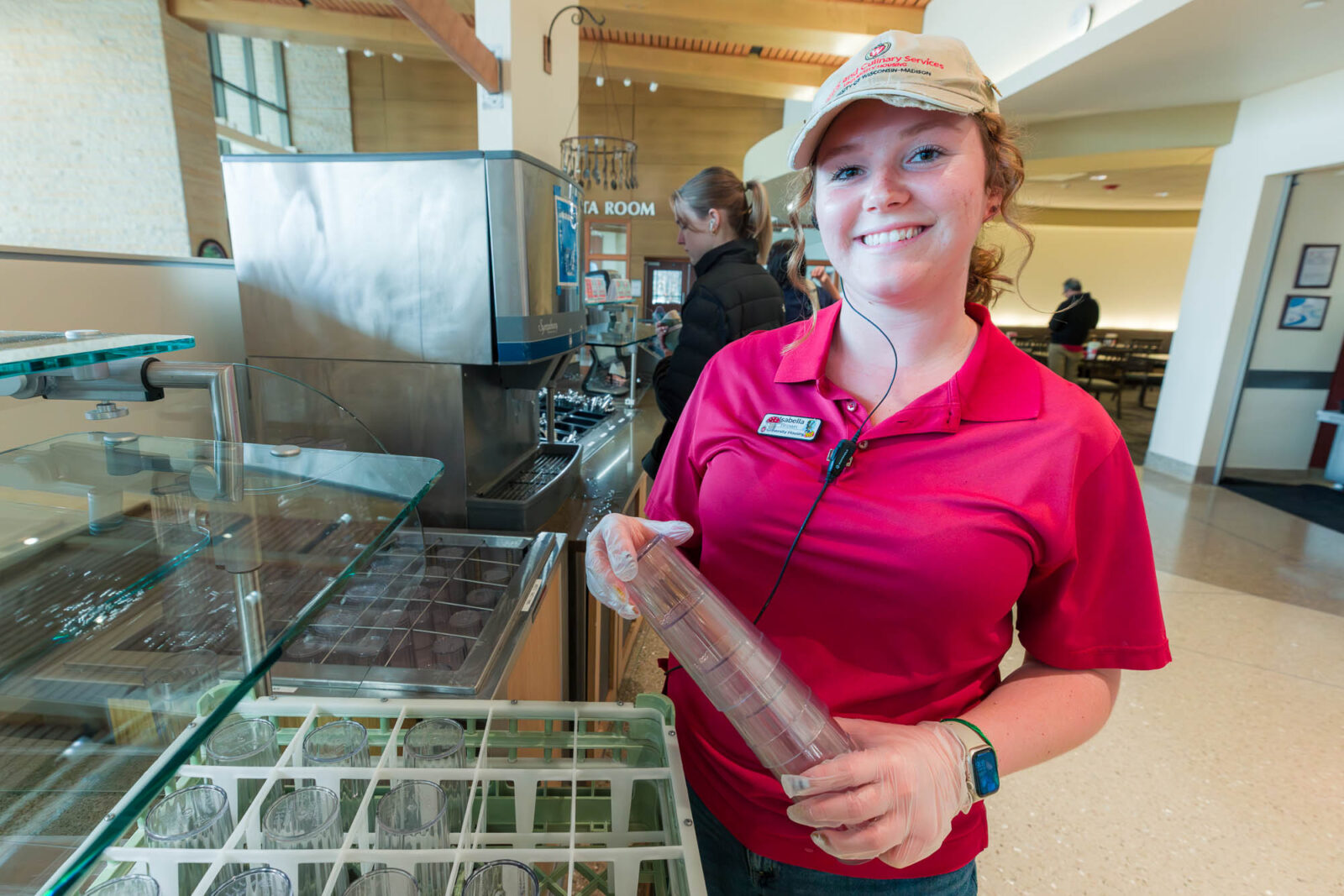 Isabella replenishes drinking cups in Four Lakes Market in Dejope Residence Hall.