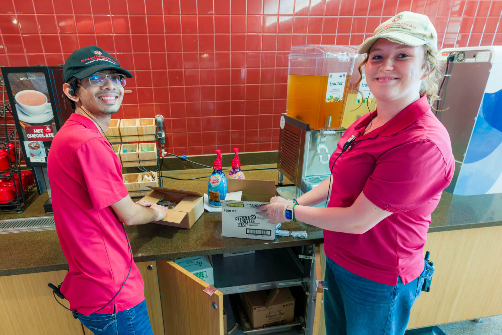 Isabella trains another student in Four Lakes Market in Dejope Residence Hall.