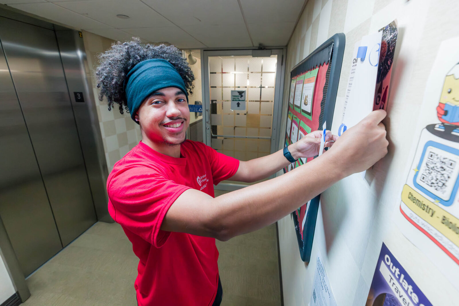 Kaden removes flyers in Lowell Center.