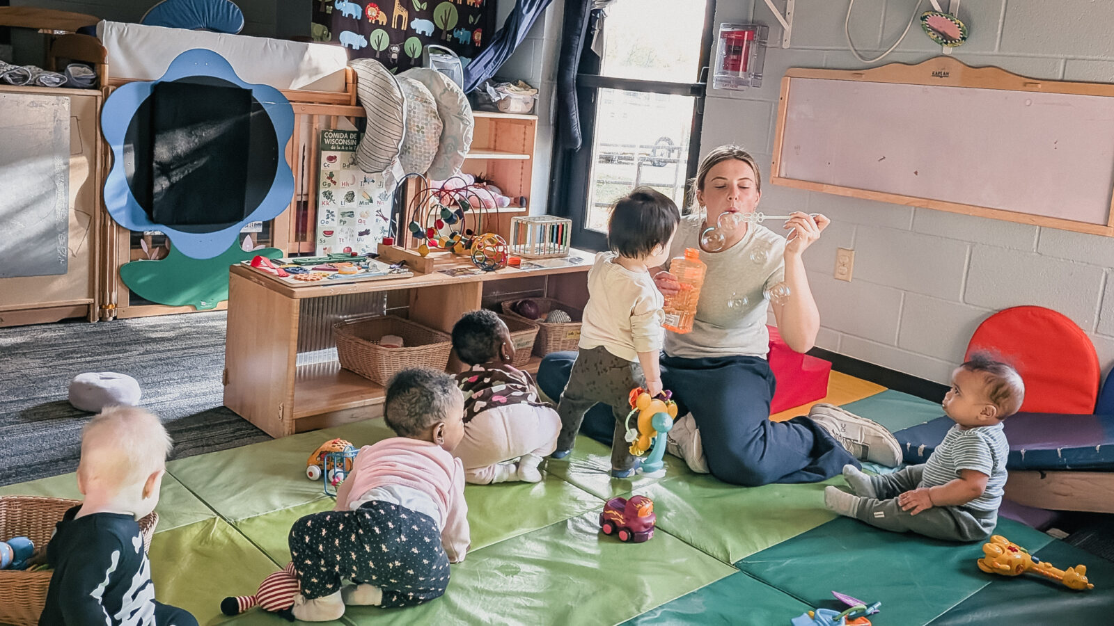 Student worker playing with Babies in Eagle's Wing Child Care center