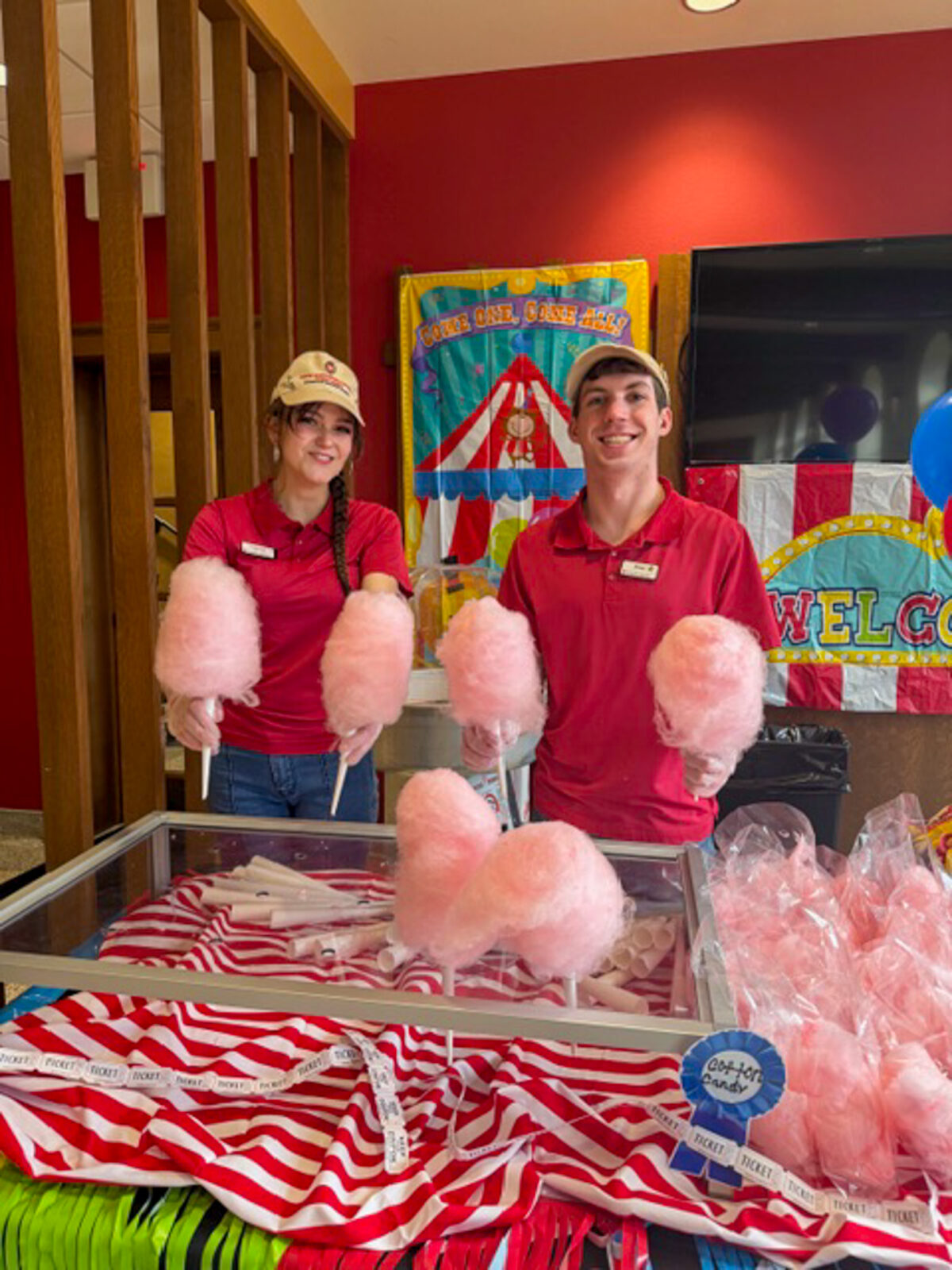 Two student staff pose for photo with cotton candy at the Fair Day event