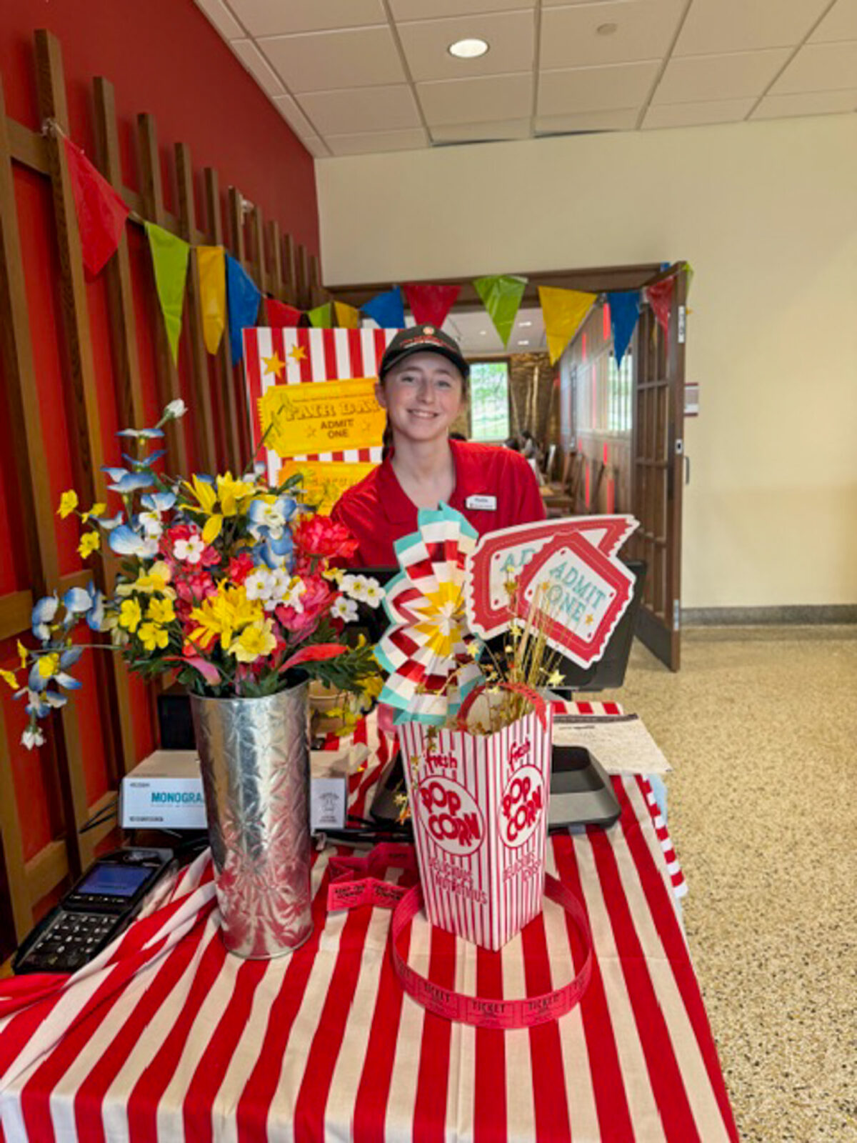 A student staff member poses for photo at the register decorated for Fair Day