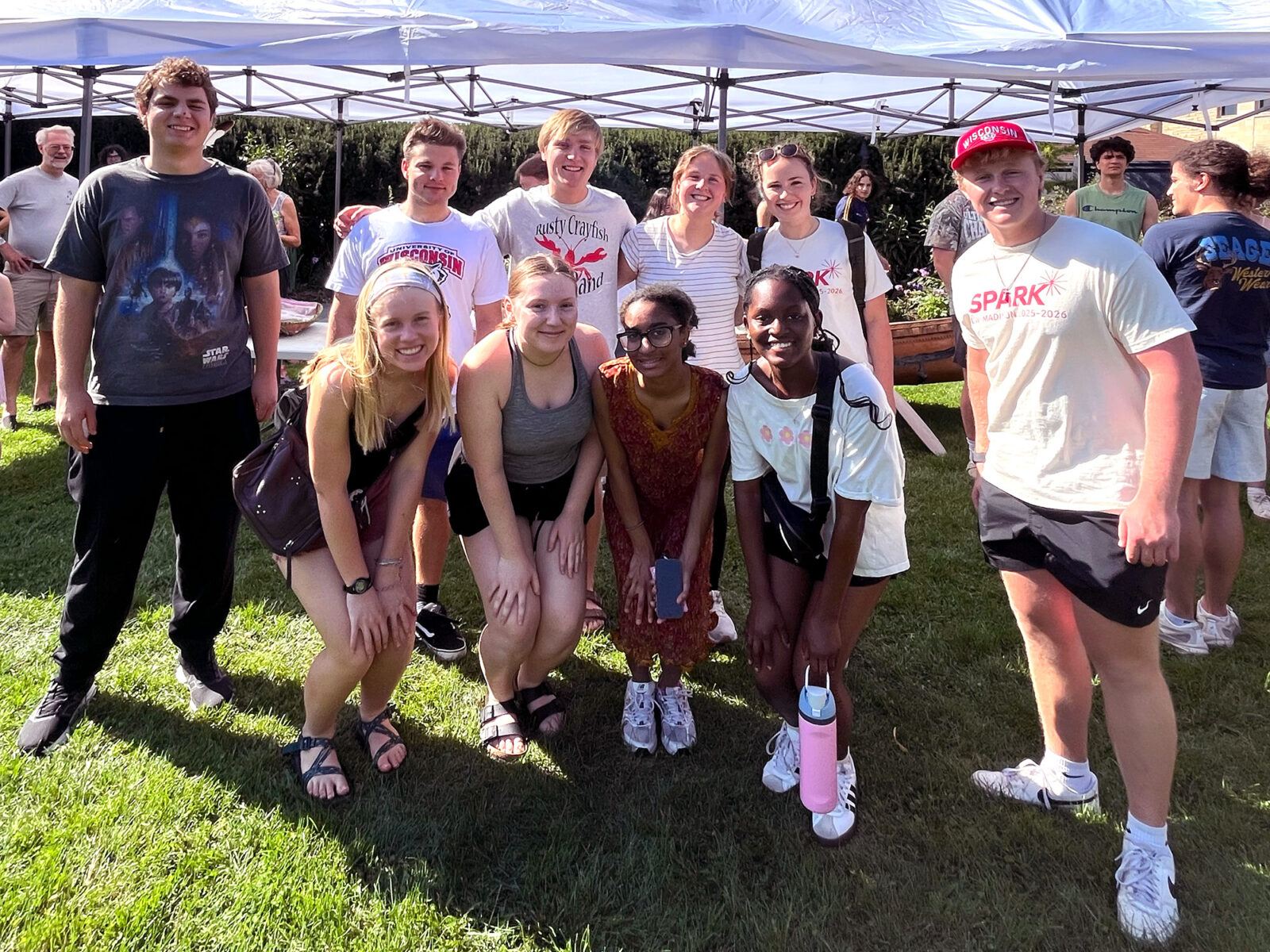 Ten Spark residents pose for a photo next to a tent.