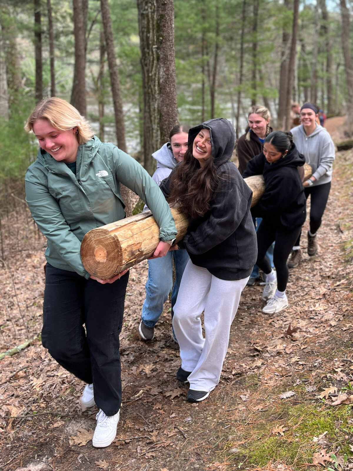 A group of Spark residents carrying a tree trunk.