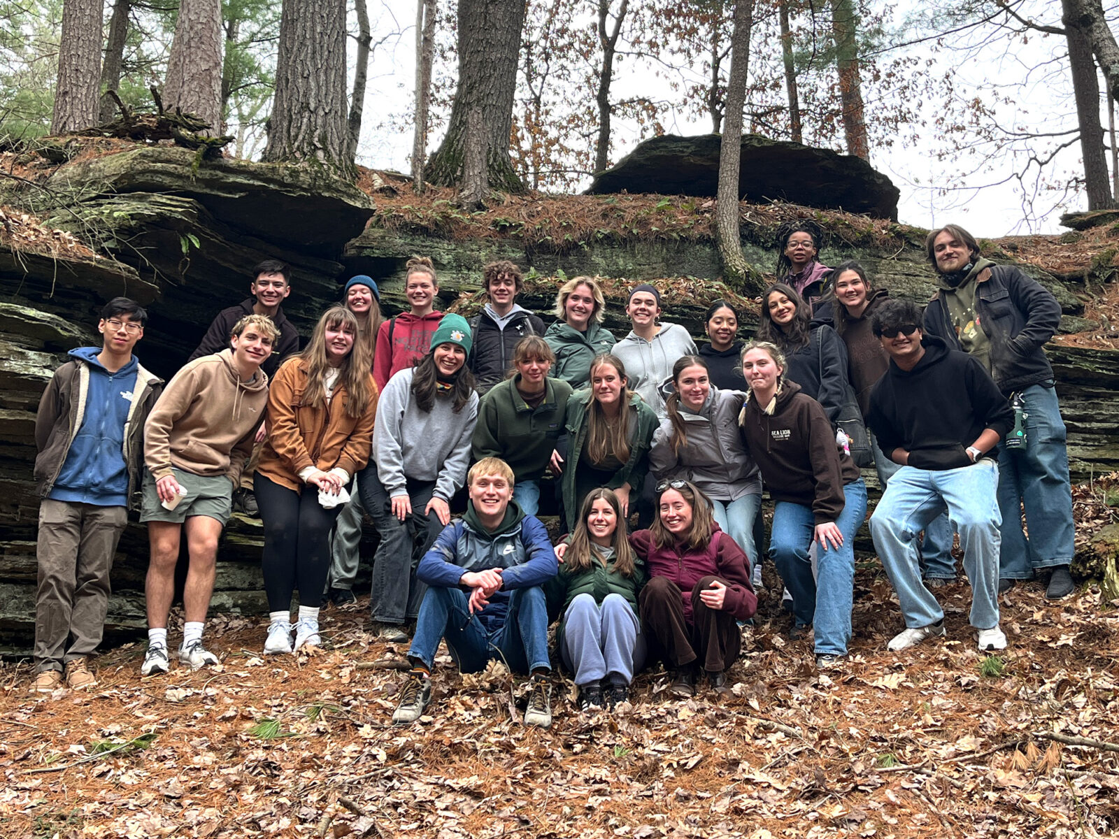 A large group of Spark residents pose for a photo with a rock outcropping behind them.