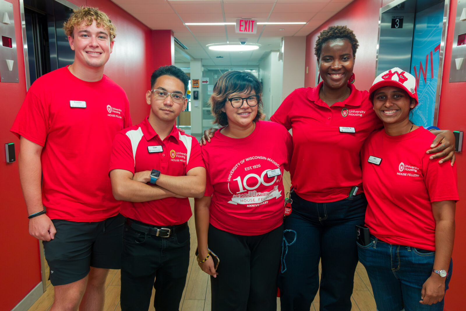 A group of five Residence Life staff and House Fellows pose in an elevator lobby