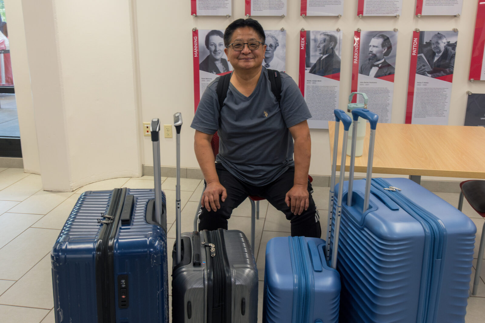 A person sitting with four suitcases in front of them