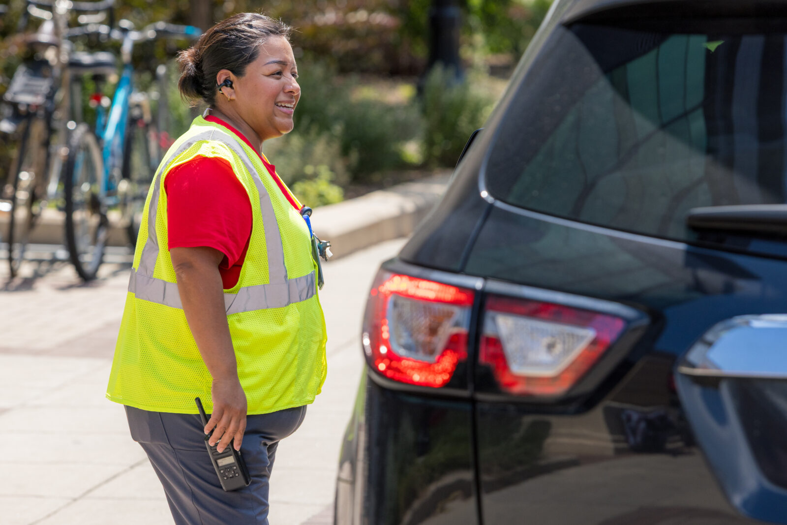 Staff standing next to a vehicle talking about parking