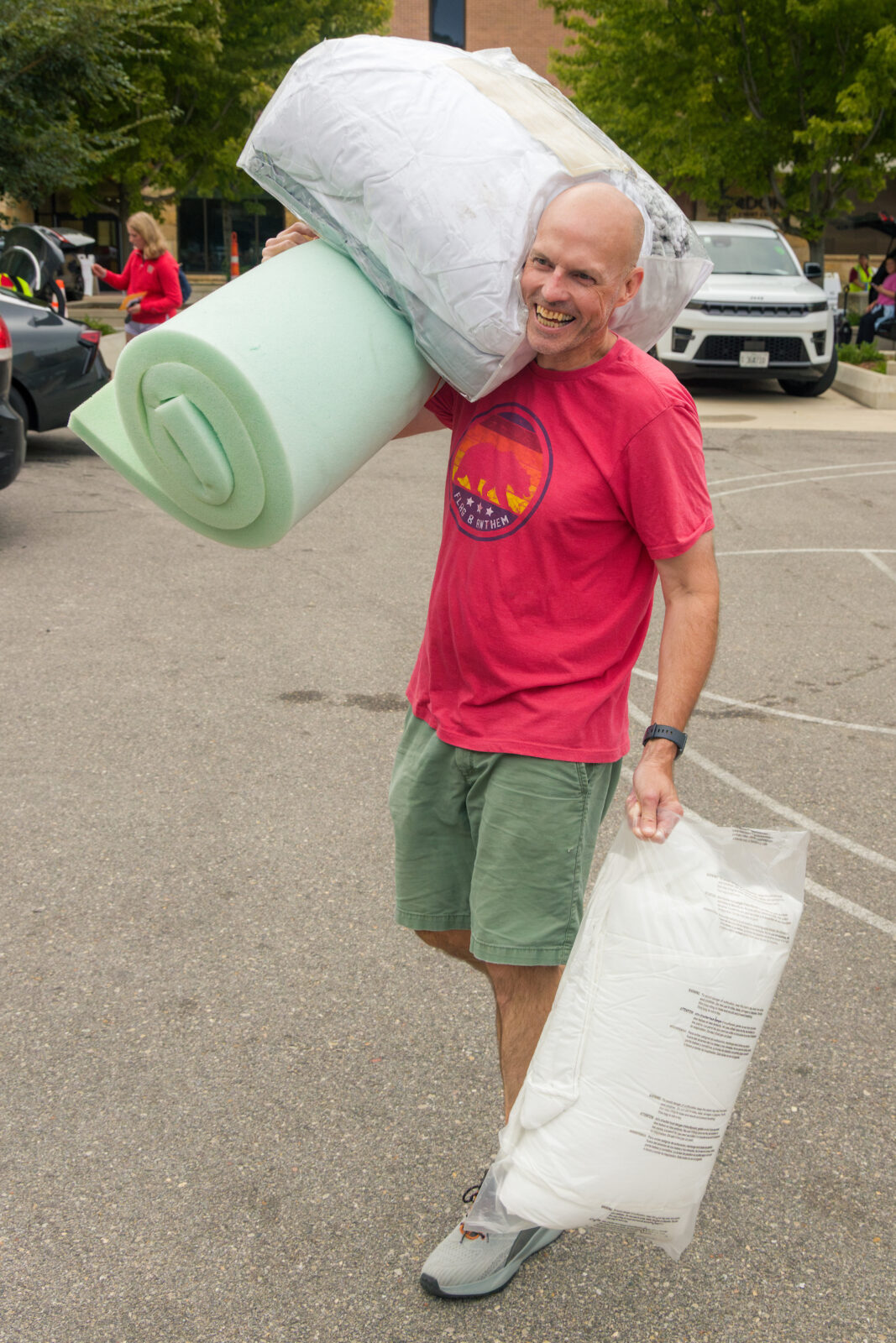 A person carrying mattresses and a mattress pad