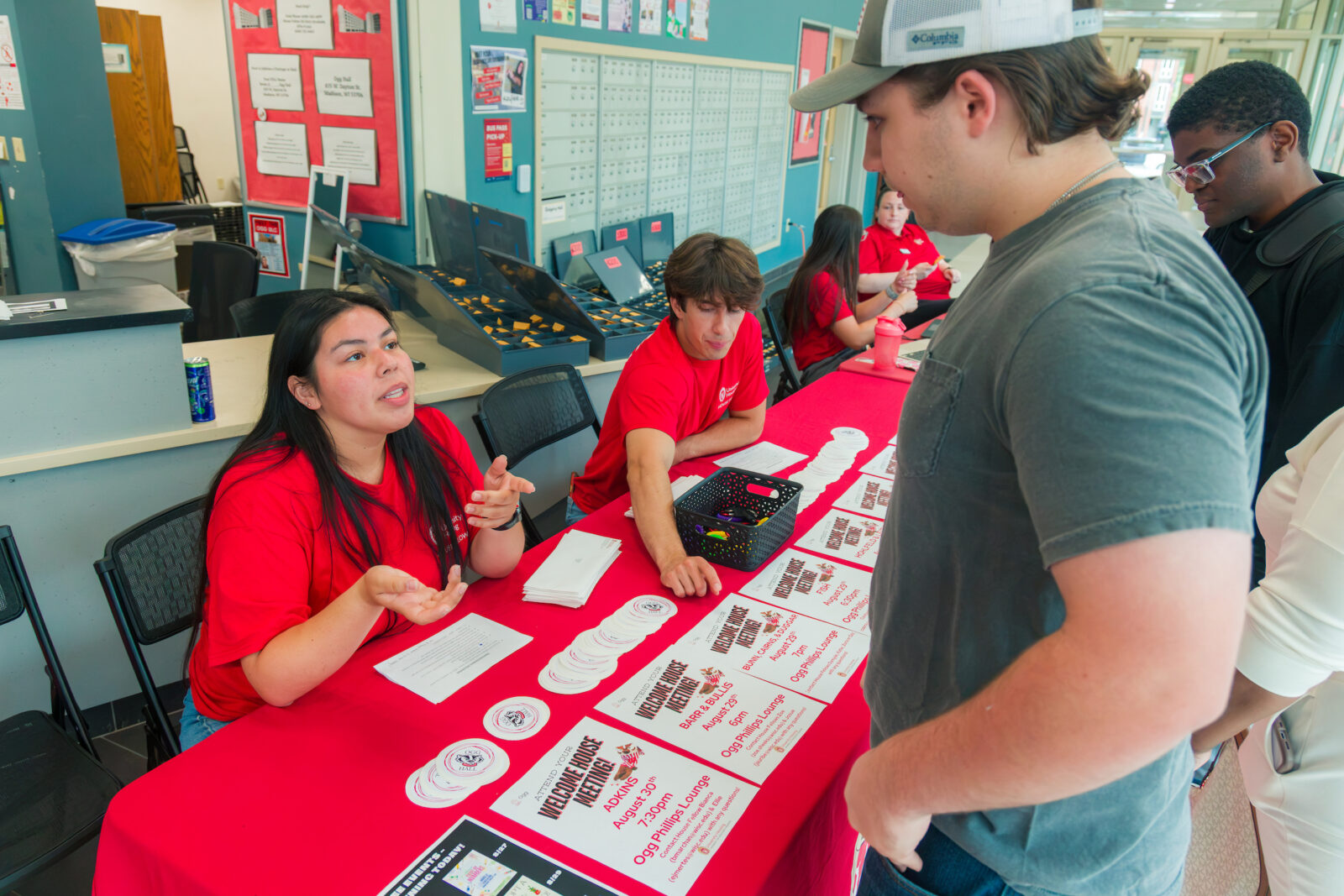House Fellows talk to people at a table about Welcome House Meetings