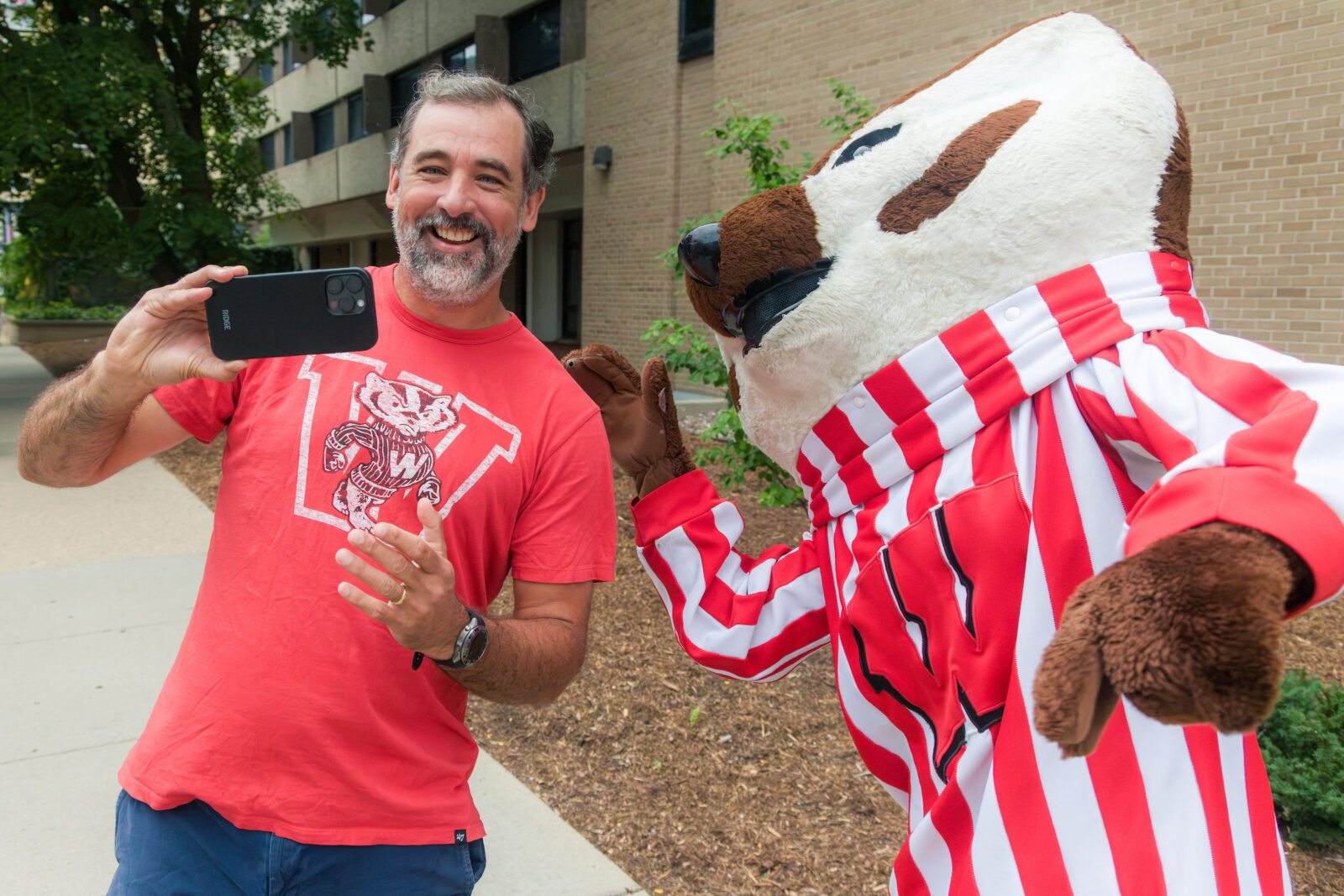 A person taking a selfie with Bucky Badger