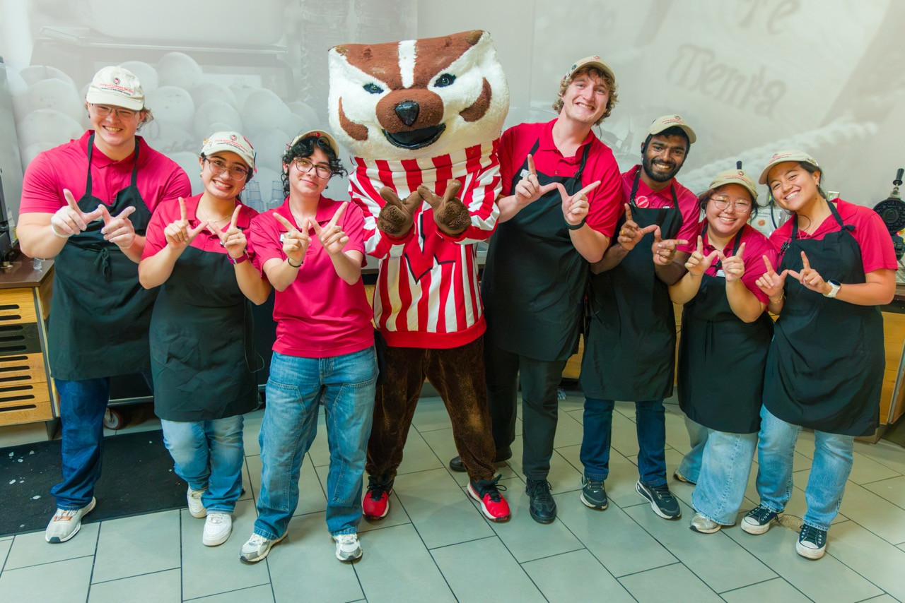 Bucky poses for photo with seven dining student staff at the Badger Welcome Dinner at Gordon