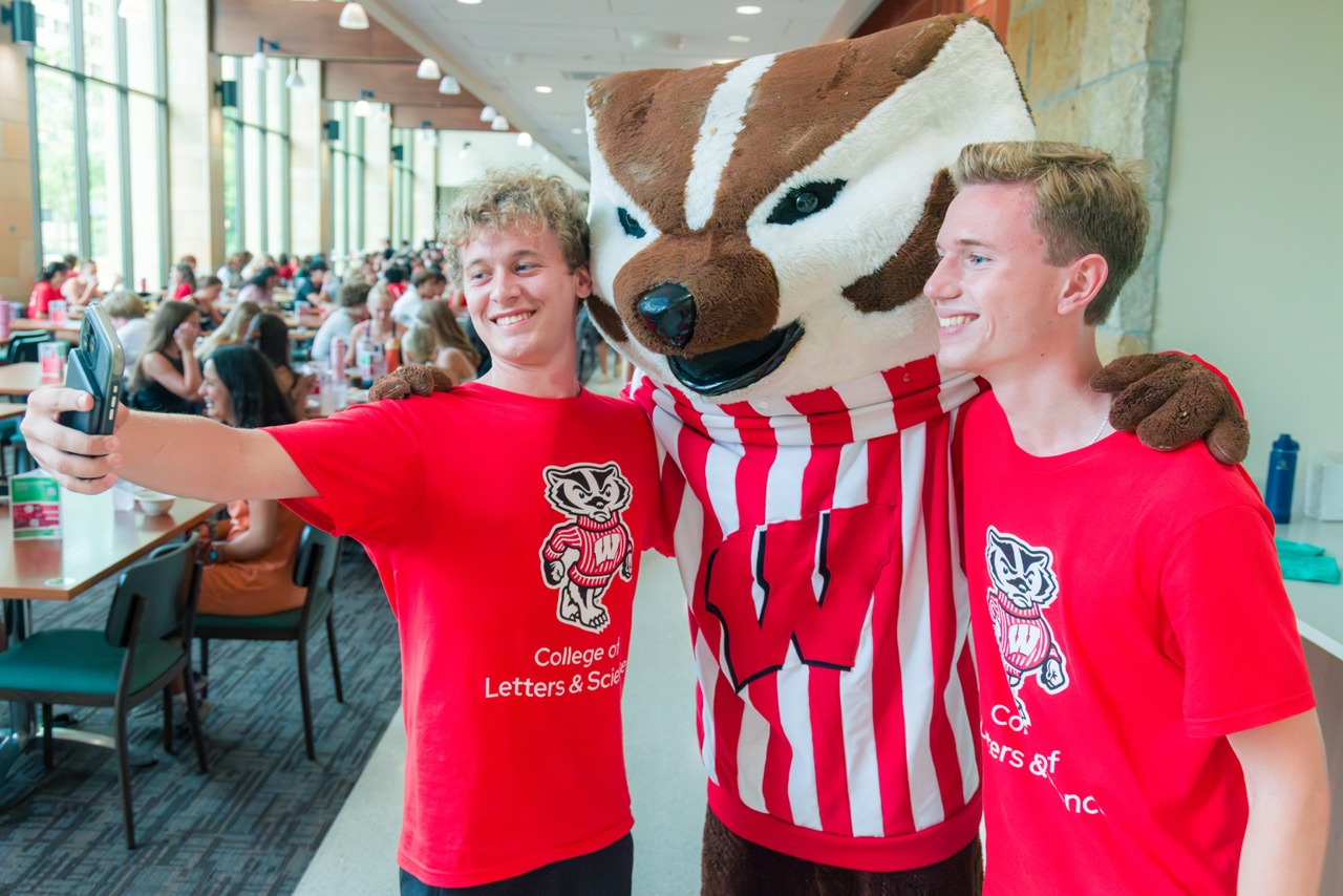 Two students take a selfie with Bucky at Gordon during the Badger Welcome Dinner