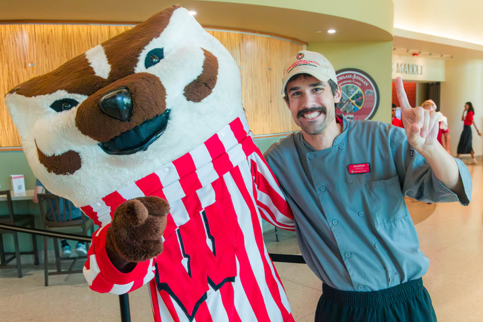 Bucky Badger poses with a Dining & Culinary Services staff member