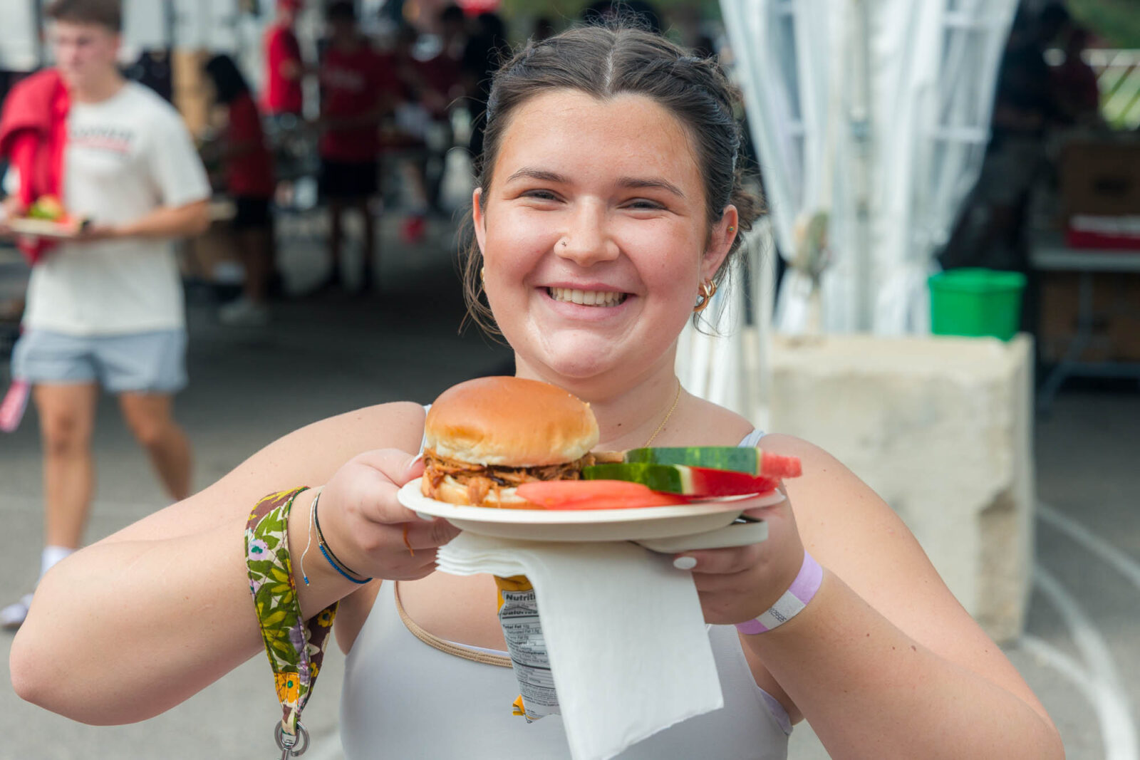 A person holding a plate full of food up to the camera