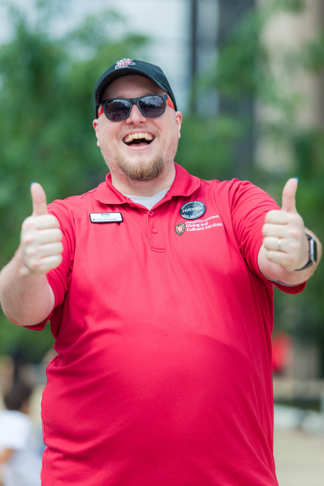 A Housing staff member gives two thumbs up while smiling