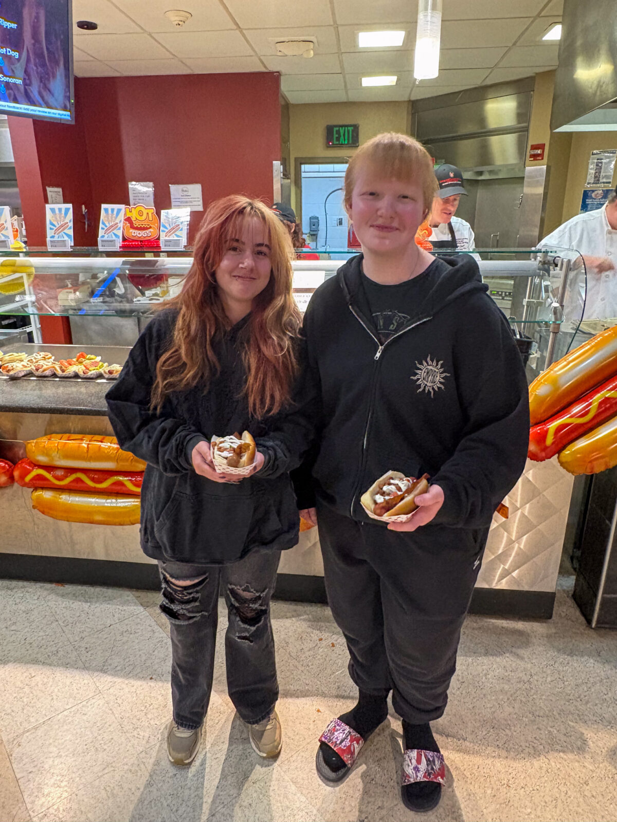 Two students pose for photo with their hot dogs
