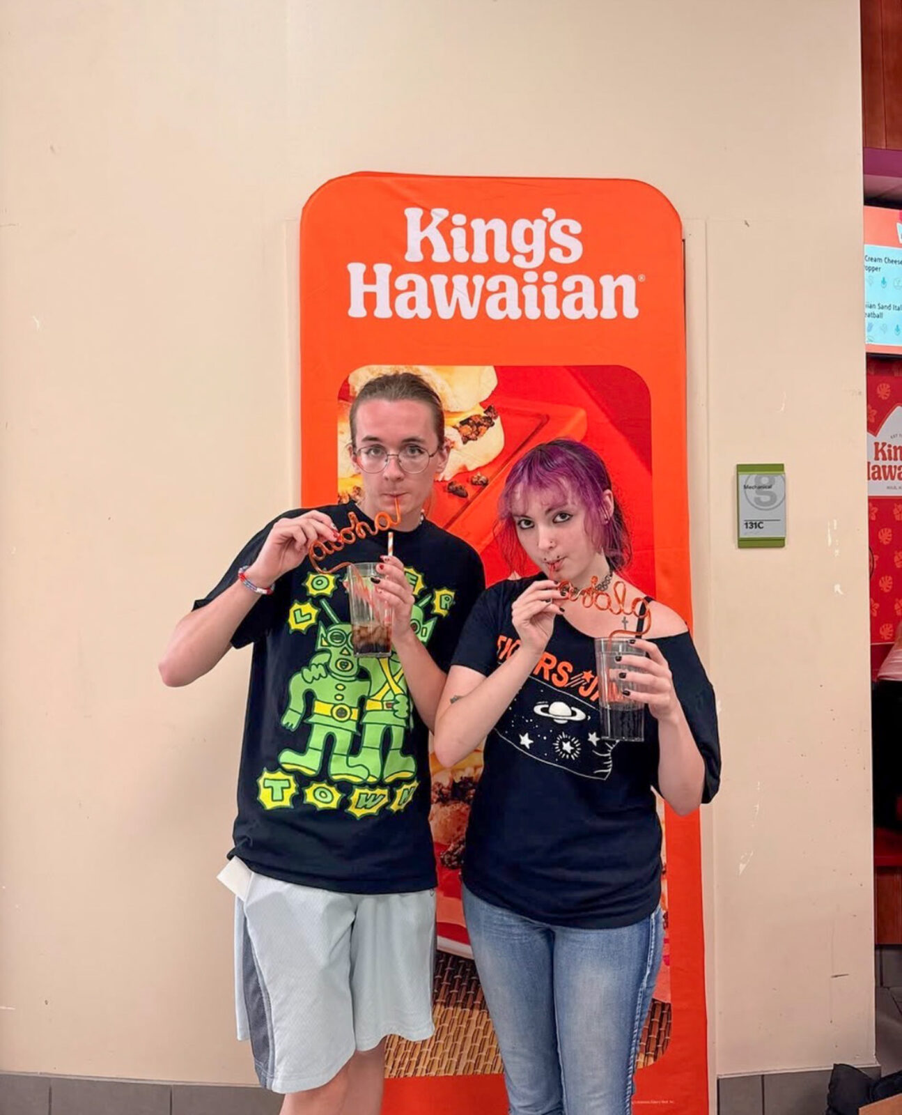 Two students pose for photo with King's Hawaiian straws at the grand opening