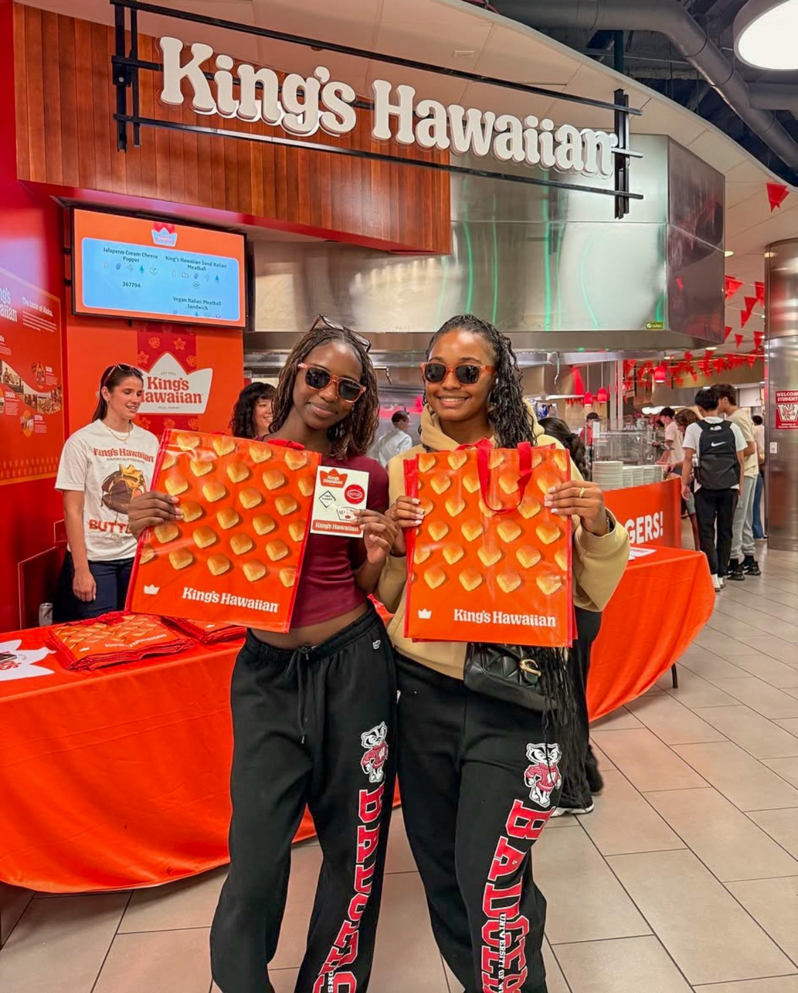 Two students pose with King's Hawaiian swag at the grand opening