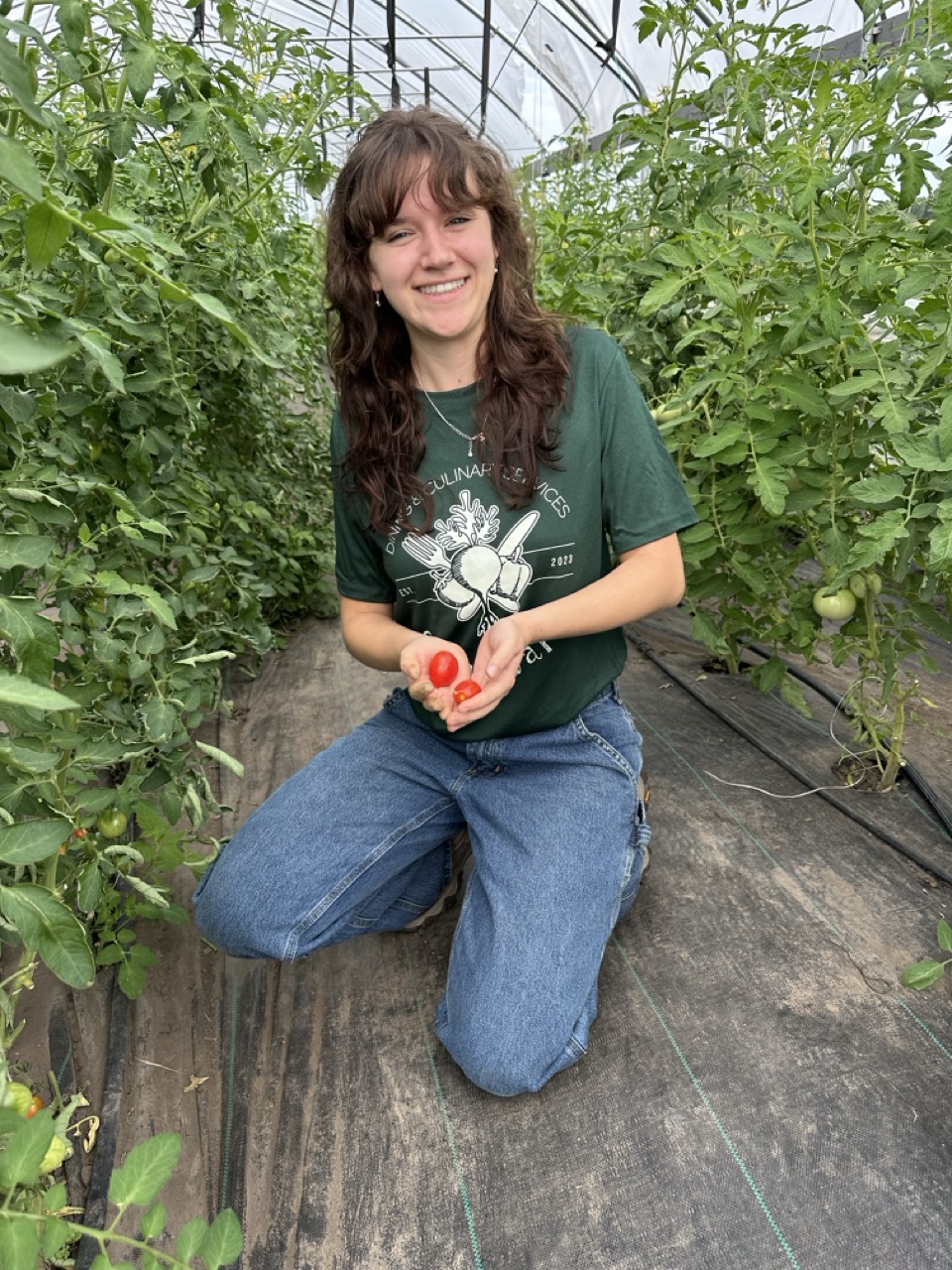 RSA student poses for photo with tomatoes at the Campus Farm